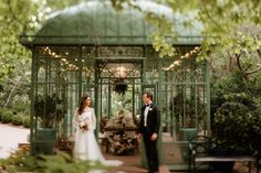 a bride and groom standing in front of a green gazebo at their wedding ceremony