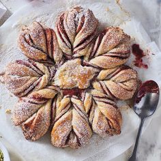 a pastry with powdered sugar and jelly on it