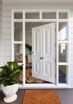 an open door leading to a room with a potted plant on the floor in front of it