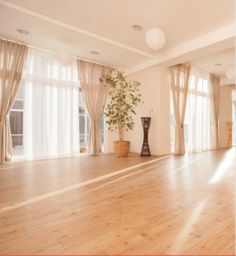 an empty room with wooden floors and large windows