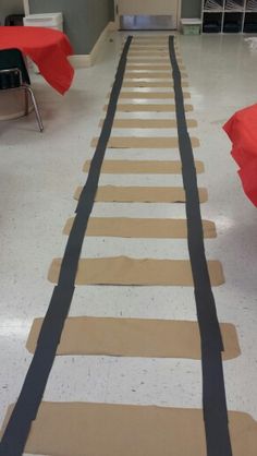 an empty room with red and black chairs on the floor covered in brown paper strips