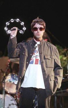 a man in sunglasses and a jacket holding up a paper plate with a skull on it