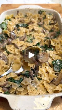 a casserole dish with mushrooms, spinach and cheese being spooned into it