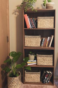 a bookshelf with baskets and plants in it