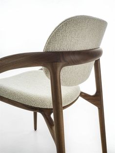 an upholstered chair with wooden arms and backrests