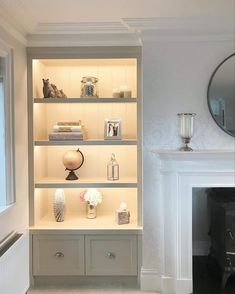 a living room filled with furniture and a fire place in front of a mirror on the wall