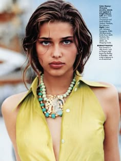 a woman wearing a yellow shirt and necklace