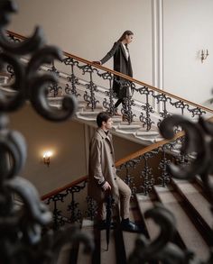 two people walking up the stairs in a building