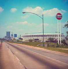 an empty highway with a stadium in the background