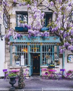 an old building with purple wisters growing on it's windows and doors