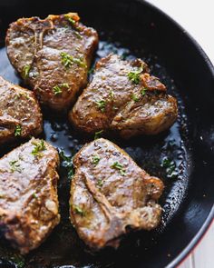 four steaks are cooking in a skillet