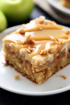 a piece of cake on a plate with caramel drizzle and apples in the background