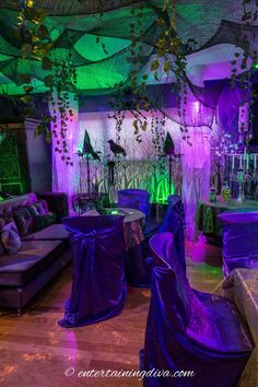 a room decorated with purple and green lights, couches and tables covered in cloths