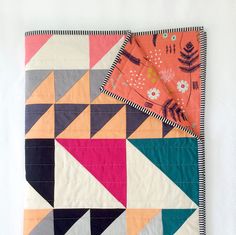 a colorful quilt hanging on the wall