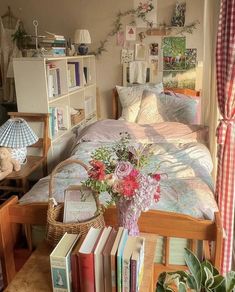 a bedroom with a bed, bookshelf and flowers on the table next to it