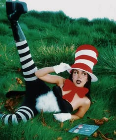 a woman laying on the ground wearing a cat in the hat costume and striped stockings