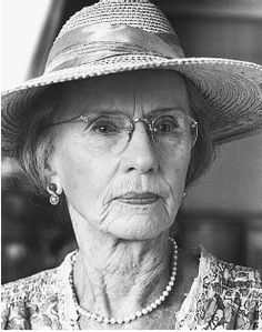 an old woman wearing a hat and pearls