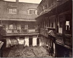 an old black and white photo of people standing in front of a building with balconies