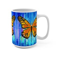 a coffee mug with two yellow butterflies painted on the side and blue water behind it