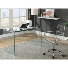 an office desk with clear glass top and chrome base, in front of a large window