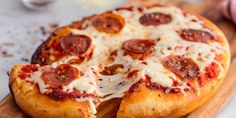 two slices of pepperoni pizza on a wooden cutting board