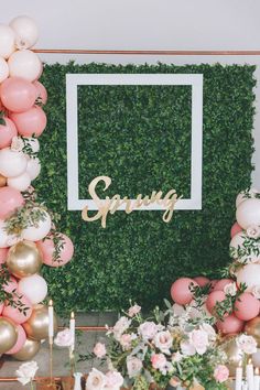 a table with balloons, candles and flowers in front of a backdrop that says spring