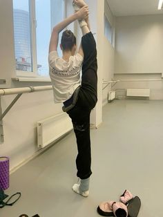 a person standing on one leg with their feet in the air while another person is doing a handstand