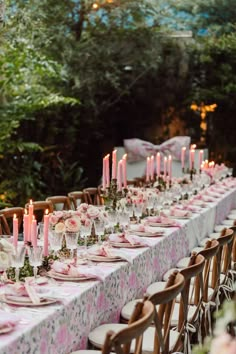 a long table is set with pink and white linens for an elegant dinner party