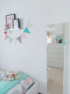 a bedroom with a bed, mirror and toys on the wall in front of it