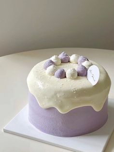 a cake with white frosting and purple decorations