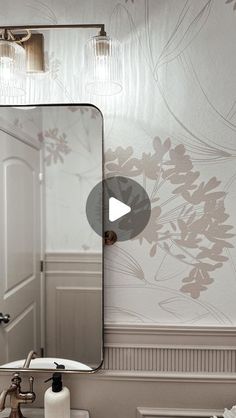 a bathroom sink sitting under a mirror next to a wall mounted faucet with lights on it