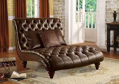 a brown leather chaise lounger sitting on top of a rug in a living room