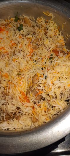 a pan filled with rice and carrots on top of a stove