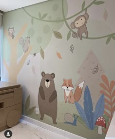 a wall mural with animals and leaves on it in a child's room,