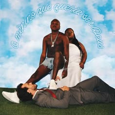 two men and a woman laying on the ground in front of a blue sky with clouds