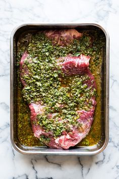 raw meat in a pan with herbs and seasoning