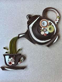 a teapot shaped like a fish with buttons on it's back and handles