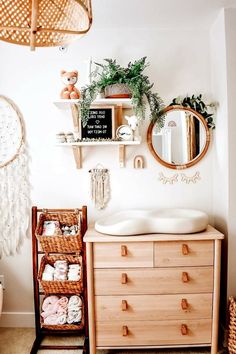 a bathroom with a dresser, mirror and shelf filled with baby items on it's side