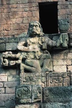 an ancient statue on the side of a building