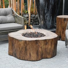 a fire pit sitting on top of a wooden table next to a couch and chair