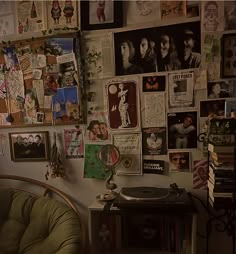 a room filled with lots of posters and pictures on the wall next to a record player