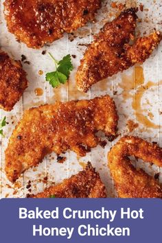 baked crunchy hot honey chicken on a sheet of parchment paper with parsley sprigs