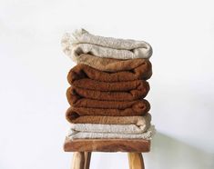 a stack of towels sitting on top of a wooden stool