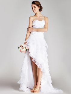 a woman in a white wedding dress standing next to a flower bouquet