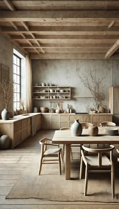 a table and chairs in a room with wooden flooring, walls and ceiling beams