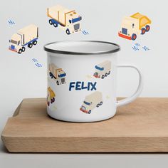 a white enamel mug sitting on top of a wooden table with magnets flying around it