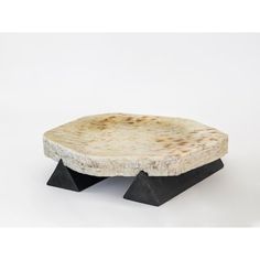 a piece of food that is sitting on top of a black stand and white background