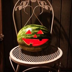 a watermelon sitting on top of a white chair