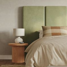 a bedroom with a green headboard and beige bedding