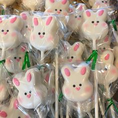 some white and pink bunny lollipops in plastic wrappers with green bows